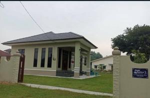 a small house with a sign in front of it at Kuzarisma homestay in Bachok