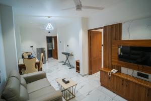 a living room with a couch and a flat screen tv at DQ Premium Apartments in Ernakulam