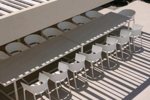 a group of chairs sitting around a table on a deck at Calòre Villa, Close to Beach, Gym, Sauna & Cinema, By ThinkVilla in Pigianos Kampos
