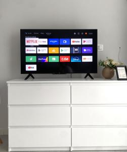 a flat screen tv sitting on top of a white dresser at SeaSide in Gdańsk