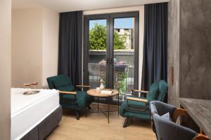 a room with green chairs and a table and a window at Lenus Hagia Sophia Hotel in Istanbul