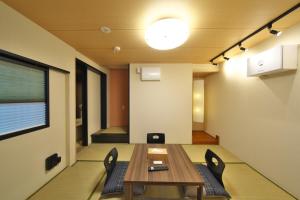 a dining room with a table and chairs and a light at 箱根御泊処-庵- 047h in Hakone