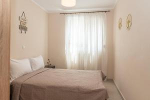a bedroom with a bed and a window at Nerida Beach Apartment in Lampi