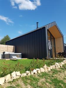 a house with a black facade with a yard at Les Chalets en Ruynes 2 in Ruynes-en-Margeride