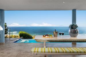 a table with wine glasses and a view of the ocean at Breakwaters on Pezula in Knysna