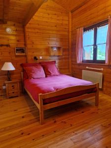a bedroom with a bed in a log cabin at Les Chryolles - Les sources in Valmeinier
