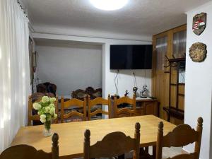 a dining room table with a vase of flowers on it at Alpesi Apartman in Bogács