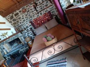 a bed in a room with a stone wall at Penelope's Guest House in Perithiótissa