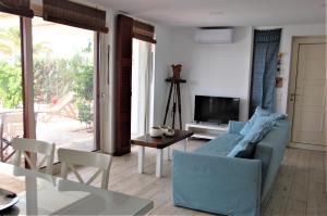 a living room with a blue couch and a table at Aegean Pearl in Áyios Dhimítrios