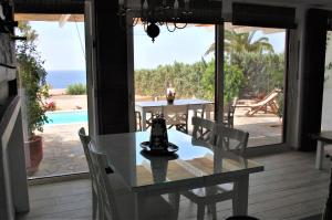 a dining room with a table and a view of the ocean at Aegean Pearl in Áyios Dhimítrios