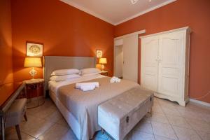 a bedroom with a large bed with orange walls at Panorama Suites Noto - Adults Only in Noto +103 photos