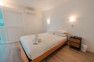 a bedroom with a bed with white sheets and pillows at Maroochydore Coastal Suite in Maroochydore