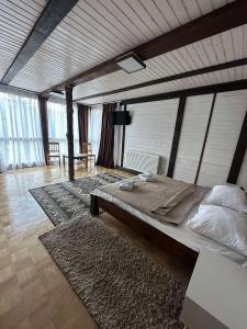 a bedroom with a large bed in a room with windows at Chalet Shepit Karpat in Bukovel
