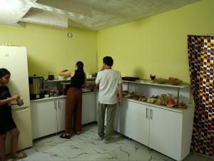 Un grupo de personas de pie en una cocina. en Registan Center Guest House, en Koshbakaly