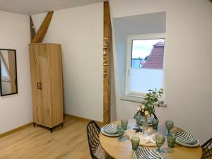 a dining room with a table and a window at Sea&Wine Apartamenty Darłówko in Darlowko