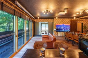 un soggiorno con tavoli, sedie e finestre di HAKONE Villa-Rin- 052H a Hakone