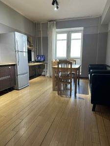 a kitchen and dining room with a table and a refrigerator at The Long White Apartment in Ulaanbaatar