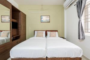 a bedroom with a large bed with white sheets at Wandr Hotel Brookefield, Bangalore in Bangalore
