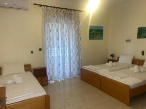 a room with two beds and a window at Ξενοδοχείο Αρετή in Loutra Edipsou