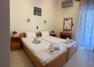 a bedroom with two beds with towels and a mirror at Ξενοδοχείο Αρετή in Loutra Edipsou