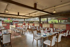 restauracja ze stołami i krzesłami w pokoju w obiekcie Saya Grand Resort By Treat Thane w mieście Dive