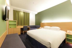 a hotel room with a large bed and a desk at Hotel Nikko Narita in Narita