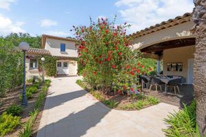 a patio with a tree with red flowers on it at Villa Lavyn in Grimaud