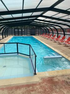 una grande piscina con sedie in un edificio di Mobil home dans camping 4 étoiles au calme a Saint-Hilaire-de-Riez