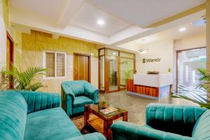 a living room with blue furniture and a tub at Wandr Hotel Brookefield, Bangalore in Bangalore
