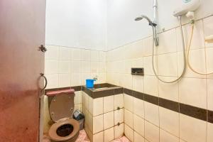 a bathroom with a toilet and a shower at Hotel Garuda RedPartner in Jakarta +11 photos