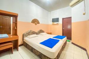 a room with a bed and a desk and a bed sidx sidx sidx at Hotel Garuda RedPartner in Jakarta