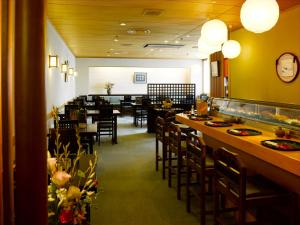 a dining room with tables and chairs in a restaurant at Hotel Nikko Narita in Narita