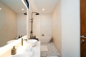 a bathroom with two sinks and a tub at Villa Onetti - Luxury Villa with Private Pool, Rooftop & Rice Field Views in Tumbak Bayuh
