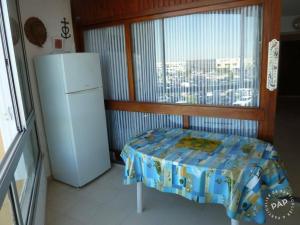 a small kitchen with a refrigerator and a window at Studio Cabine Climatisé tout près de la plage in Le Grau-du-Roi