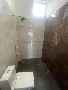 a bathroom with a white toilet and a shower at Nirvan Stays with Pool ,Indore Bhopal Highway 