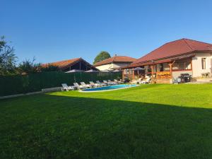 a yard with a pool and chairs and a house at Къща за гости Алтея in Sarovtsi