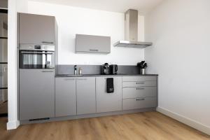 a kitchen with white cabinets and a sink at Apartment Havenzicht 10B Kortgene in Kortgene