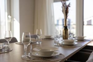 a wooden table with plates and glasses on it at Apartment Havenzicht 10B Kortgene in Kortgene
