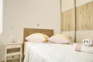 a bedroom with a bed with two pillows and a mirror at Stella Maris in Kali