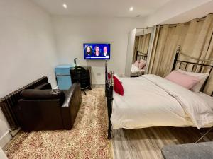ein Schlafzimmer mit einem Bett, einem Stuhl und einem Fernseher in der Unterkunft Luxe Villa, 5 En-suite Bedrooms - West London - Wembley Stadium 5KM away in Harrow on the Hill + 19 Fotos