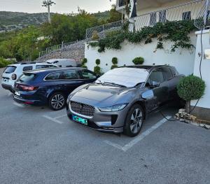 two cars parked in a parking lot next to a building at Apartmens Mendula in Senj