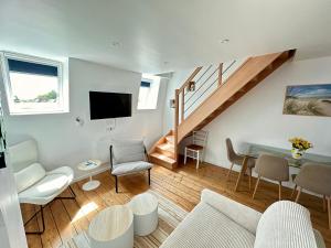 a living room with a couch and a table at Le Duplex Appartement in Abbeville