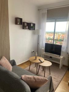 Una sala de estar con un sofá, una mesa y un televisor. en Apartamento en frente al mar de Empuriabrava, en Empuriabrava