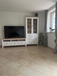 a living room with a flat screen tv on a entertainment center at 2 Personen Appartement Sonnental in Greiling