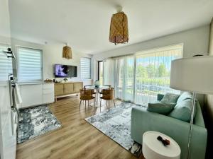 un soggiorno con un divano blu e un tavolo di Helikon Beach Apartment a Keszthely