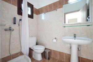 a bathroom with a toilet and a sink and a mirror at THEA Panorama Studios in Vourvourou