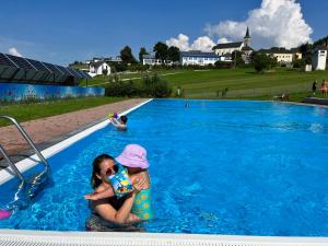 a young girl and a child in a swimming pool at Wittinghof in Julbach