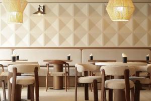 a restaurant with tables and chairs in a room at AIRINN Vilnius Airport Hotel RENOVATED 2025 in Vilnius