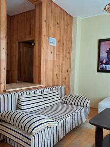 a living room with a couch and a wooden wall at Basanavičiaus kampelis in Palanga +4 photos