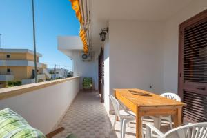 a wooden table and chairs on a balcony at Villa dei Sorrisi, Porto Cesareo in Porto Cesareo